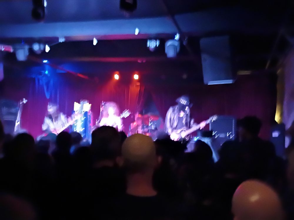 A terrible photo of a band on stage.