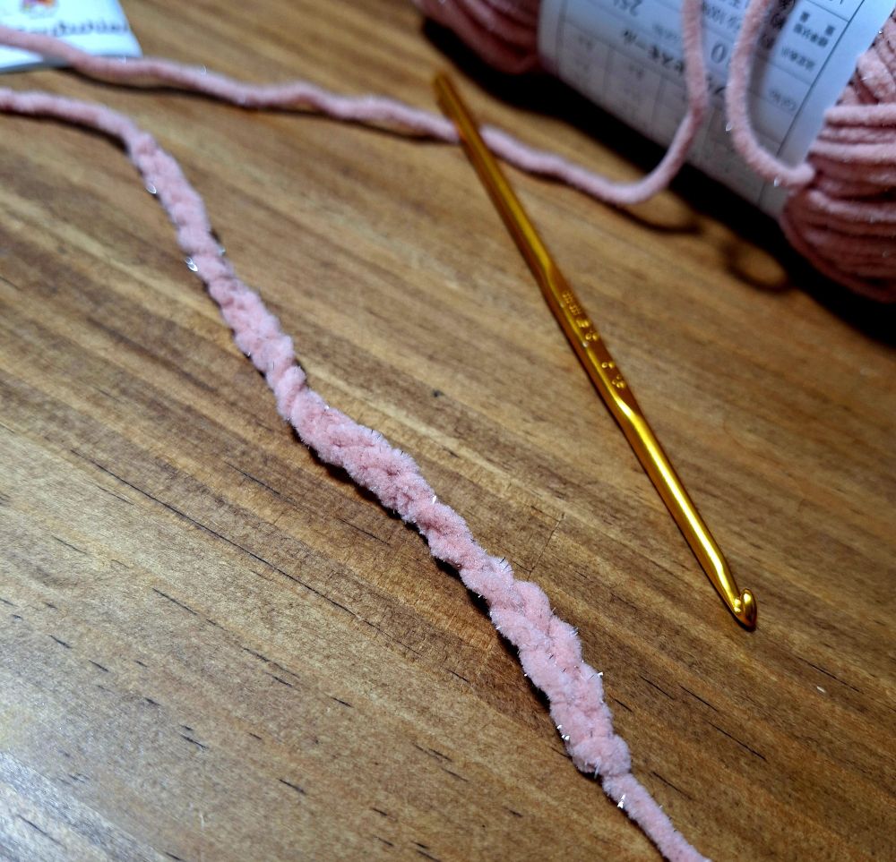 かぎ針と、くさりあみを練習しているピンクの毛糸