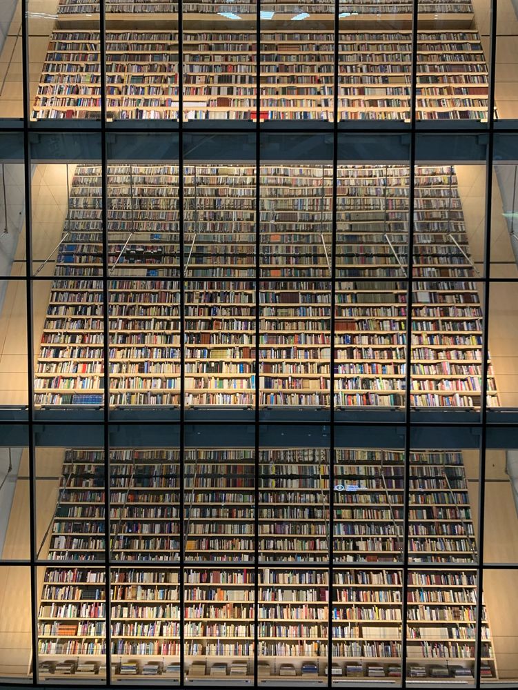 Huge shelves with books behind a glass wall