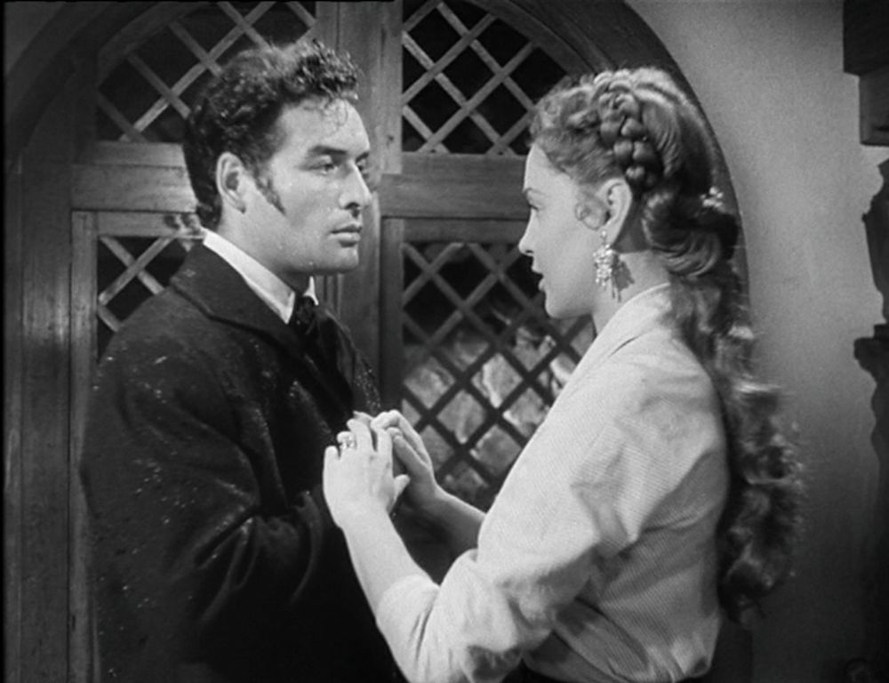 Heathcliff/Alejandro and Catalina before a wooden trellis door, ready to elope together