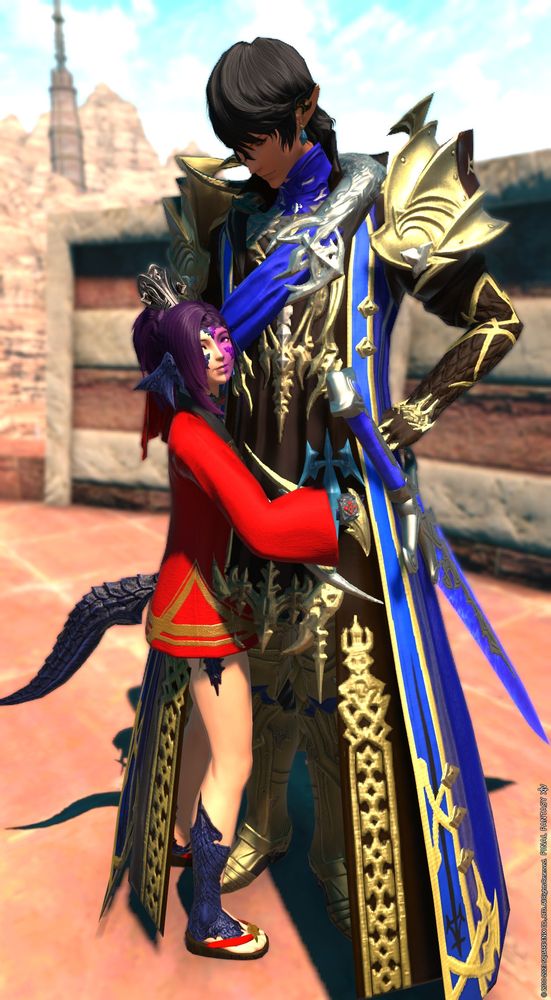 Short Au Ra woman hugging the tall Elezen man Aymeric. She's wearing a red and gold short robe that hides her shorts and black red and gold sandals and a silver headpiece. She has purple hair in a pony tail, horns for ears, scales on her legs and face, and a small dragon tail, and half her face is painted purple. The Elezen man has pointy ears and black hair. He is wearing gold armor, a blue black and gold robe with a silver buckle on the blue sash across his shoulder, and a blue silver and gold sword. She's smiling at the camera while hugging around his waste, he has an arm on his hip looking down at her with a neutral expression. 