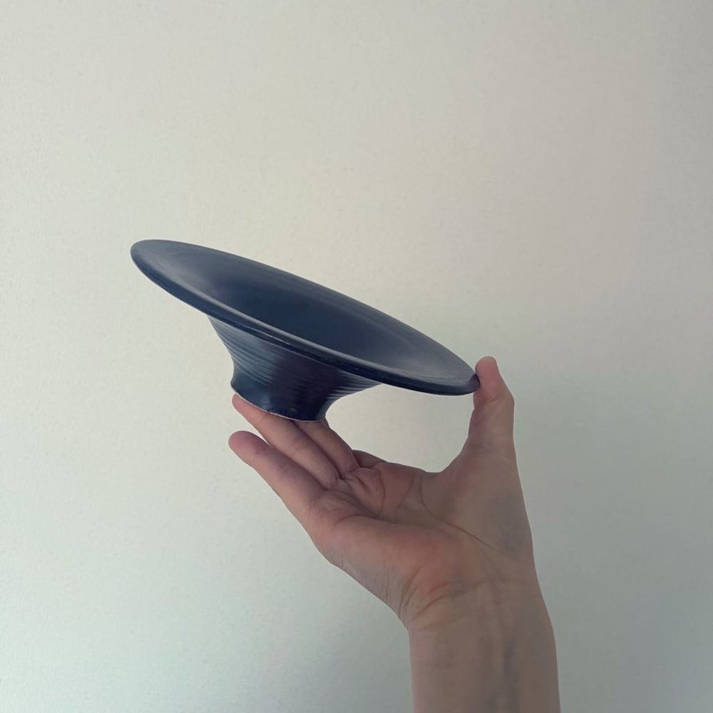 陶芸体験で作った皿を持つ手