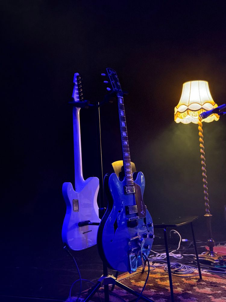 Zwei Gitarren und eine Stehlampe.