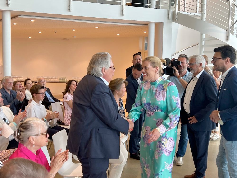 Julia Klöckner und Frank Gotthardt, Finanzier von Nius, schütteln Hände. 