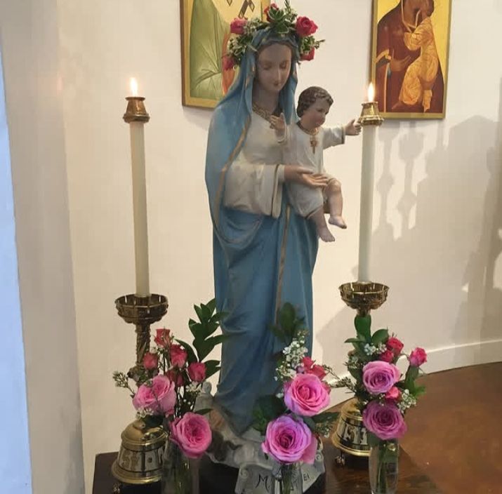 Holy Virgin with a table, candles, an flowers. Crowned with flower crown.