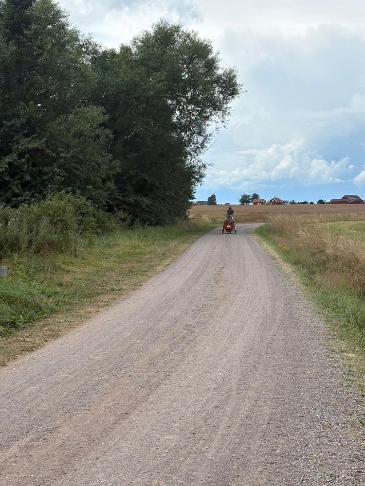 Father and daughter riding a Bakfiets down a Swedish gravel road.