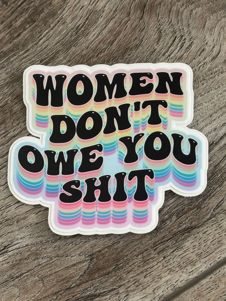Decal with rainbow coloring and black letters saying women don’t owe you shit