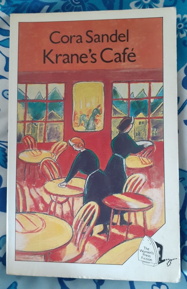 Cover of The Women's Press edition of Cora Sandel's Krane's Cafe, showing an illustration by Gill Day of two women cleaning the tables of an empty cafe, with a village and mountains visible out of two windows.
