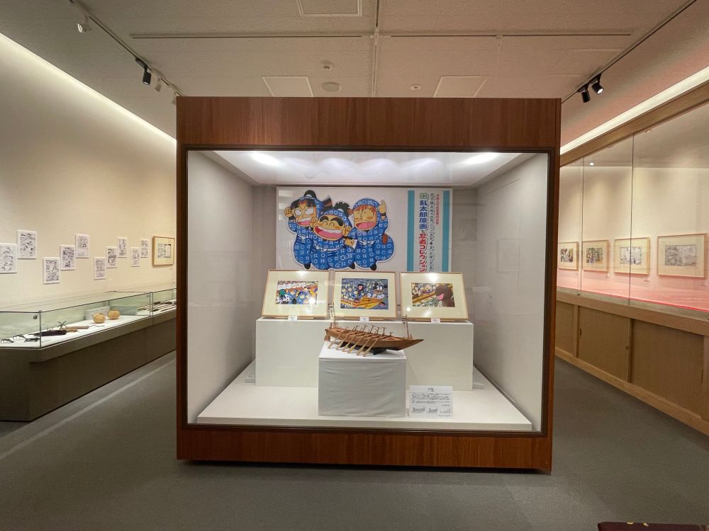 尼子先生の企画展を入口から見た様子。左右と正面に原画などが並んで展示されている。