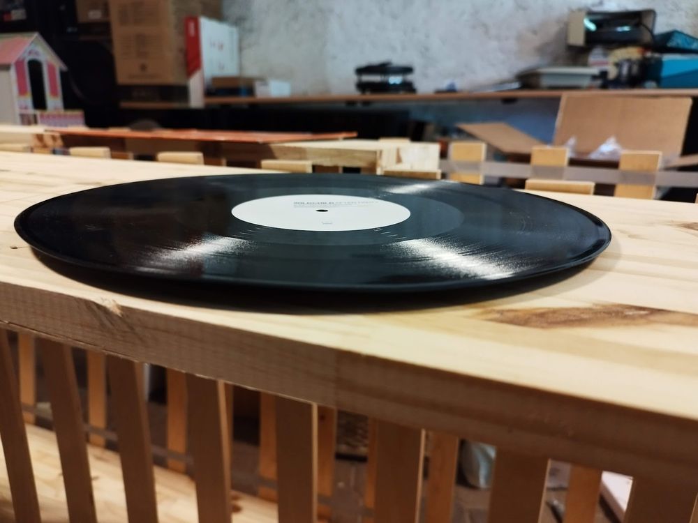 Un disque vinyl complètement voilé, posé sur une surface plate.