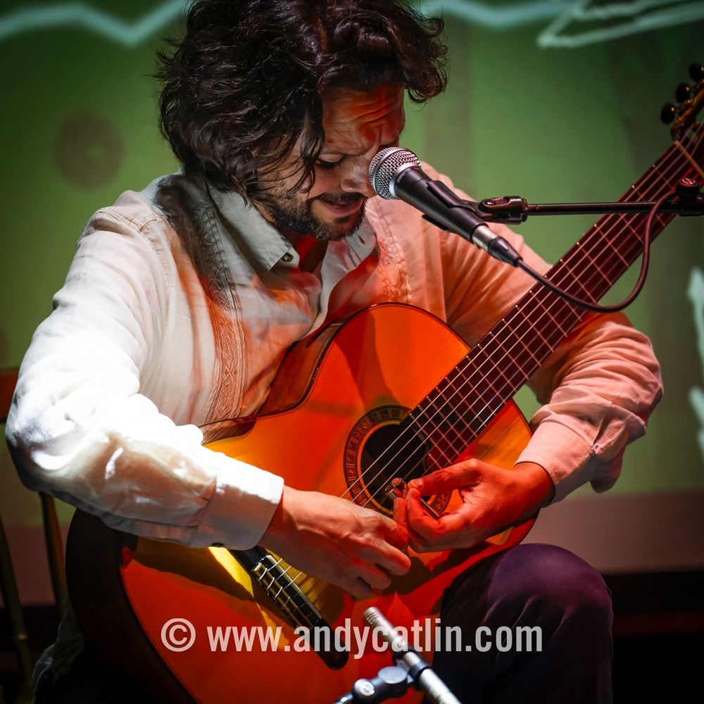An acoustic guitarist playing onstage during a concert
