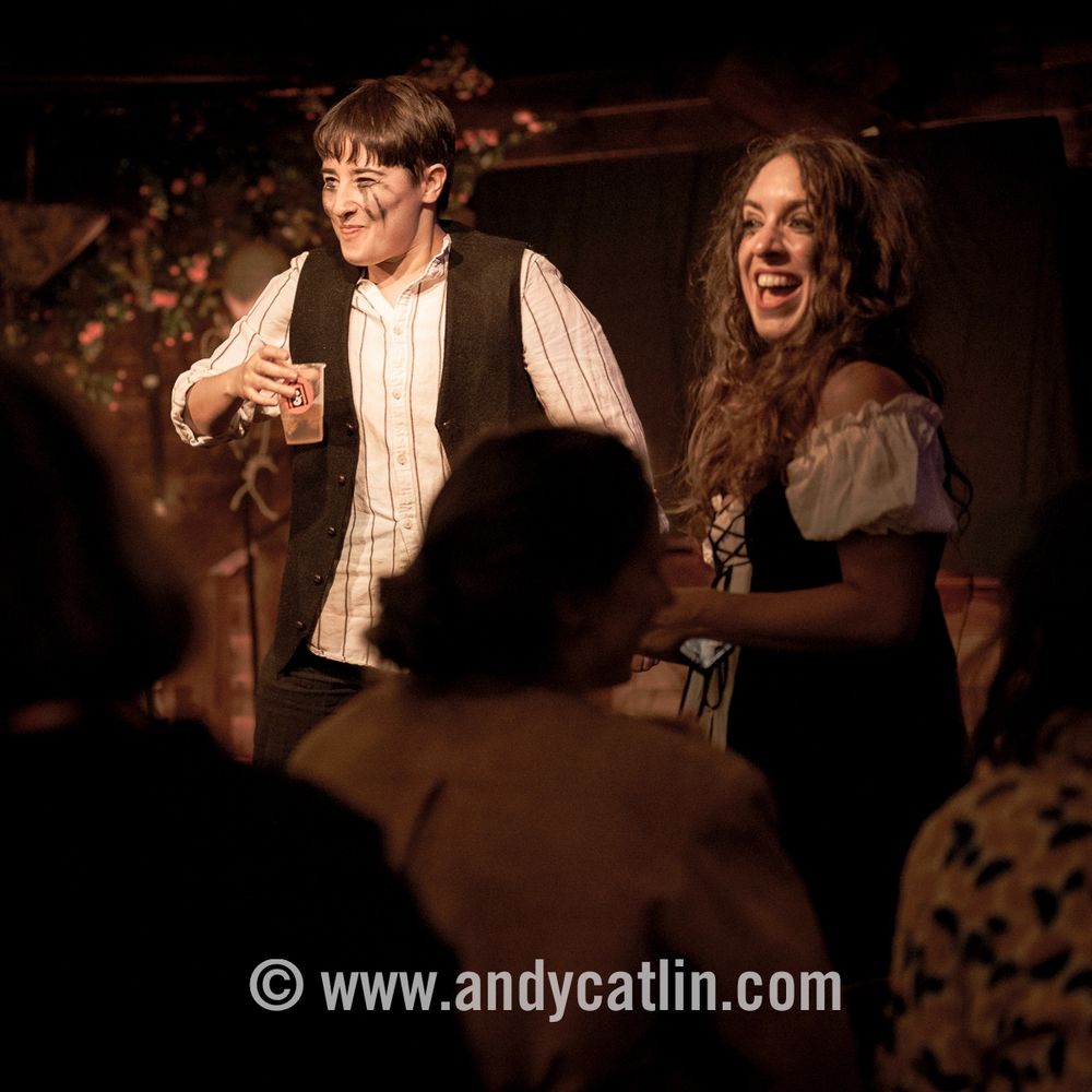 Two actors onstage smiling and laughing in a performance