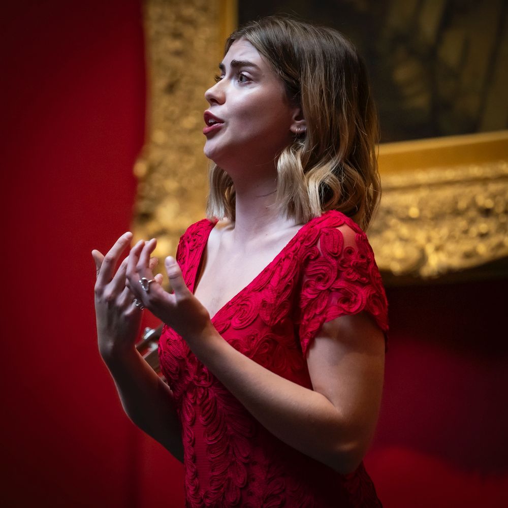 A classical music singer performing in an art gallery