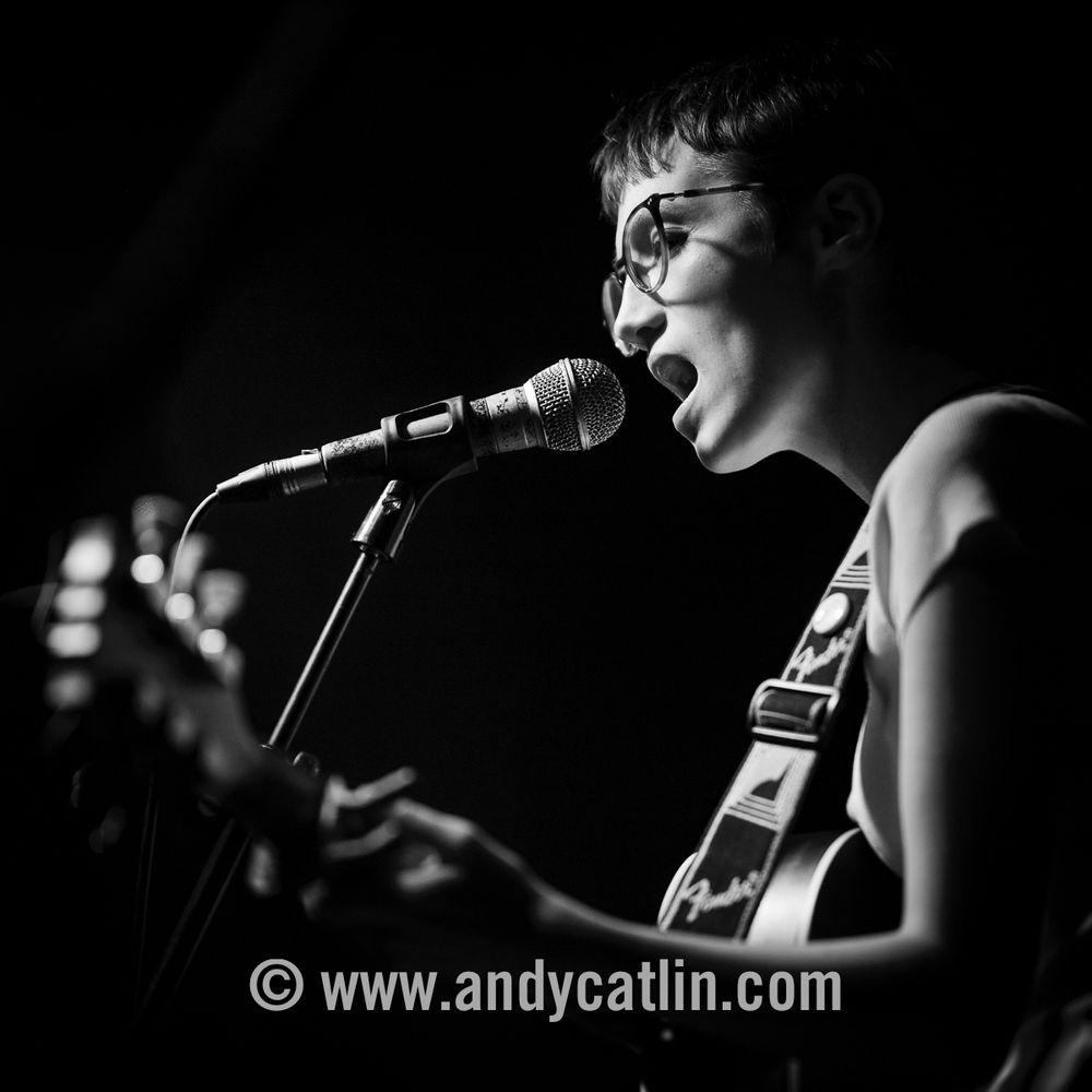 A singer onstage during a concert holding a guitar
