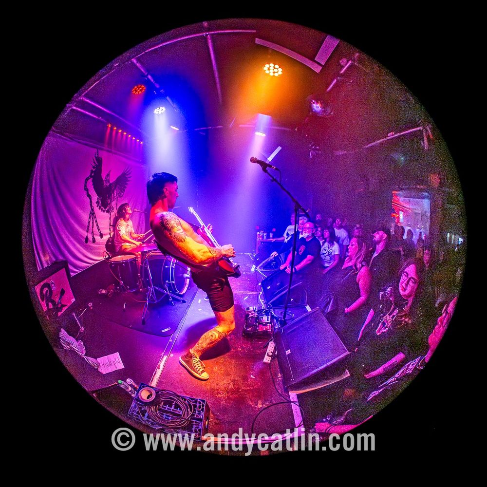 A guitarist and drummer onstage during a concert