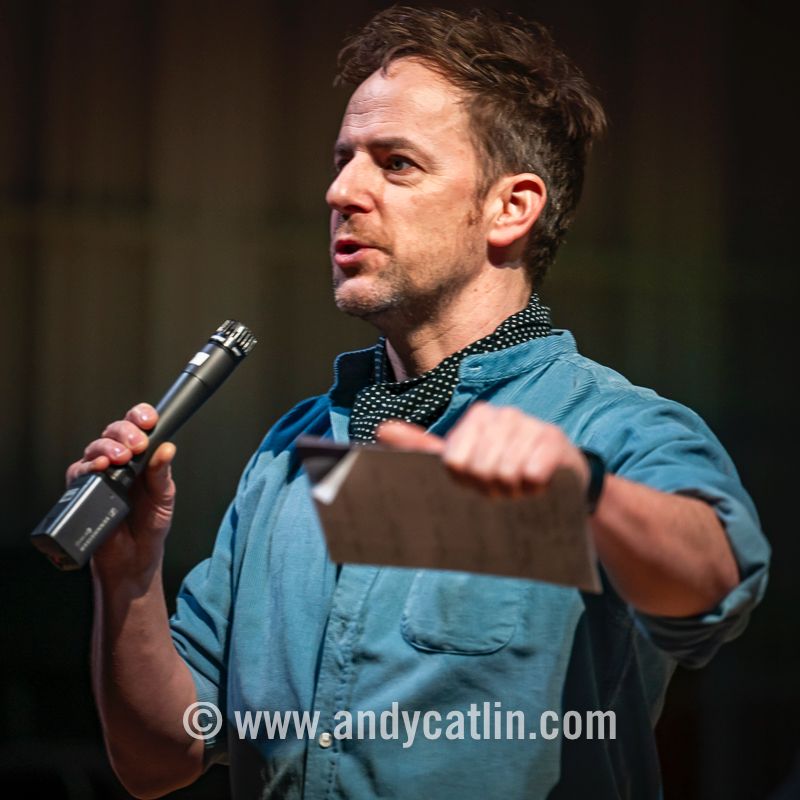 A person onstage speaking into a microphone 