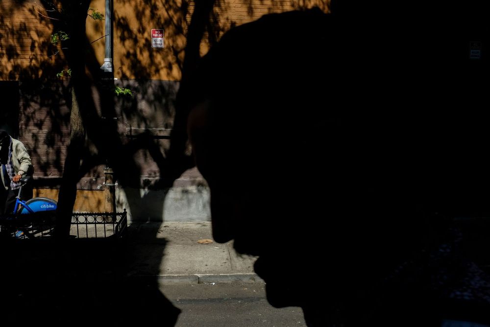 A silhouette of person is visible against a sunlit wall in Greenwich Village, Manhattan, New York.