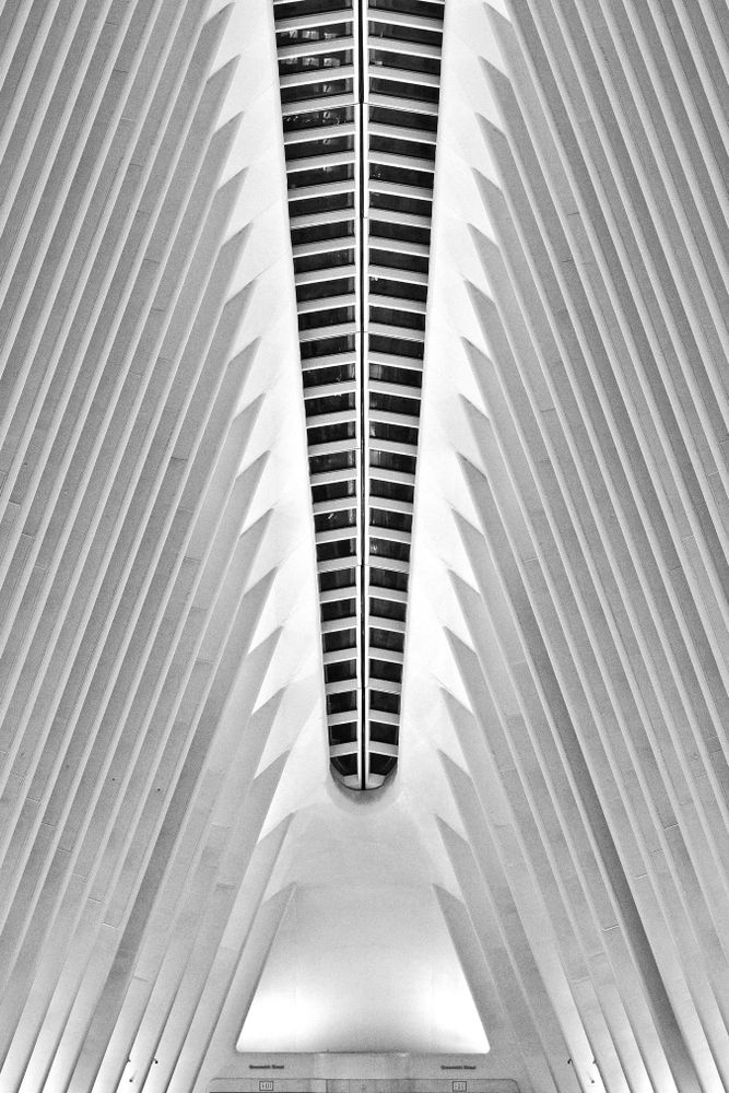 This architectural image features vertically aligned, symmetrical beams converging at a central strip, captured in the Financial District, Manhattan, New York.