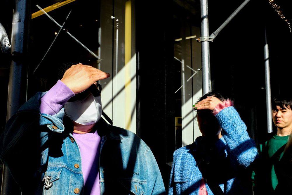 Couple shields their eyes from the sun, SoHo, Manhattan, New York City