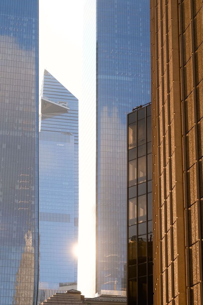 Skyscrapers with glass facades reflecting light stand tall in Midtown Manhattan, Manhattan, New York.
