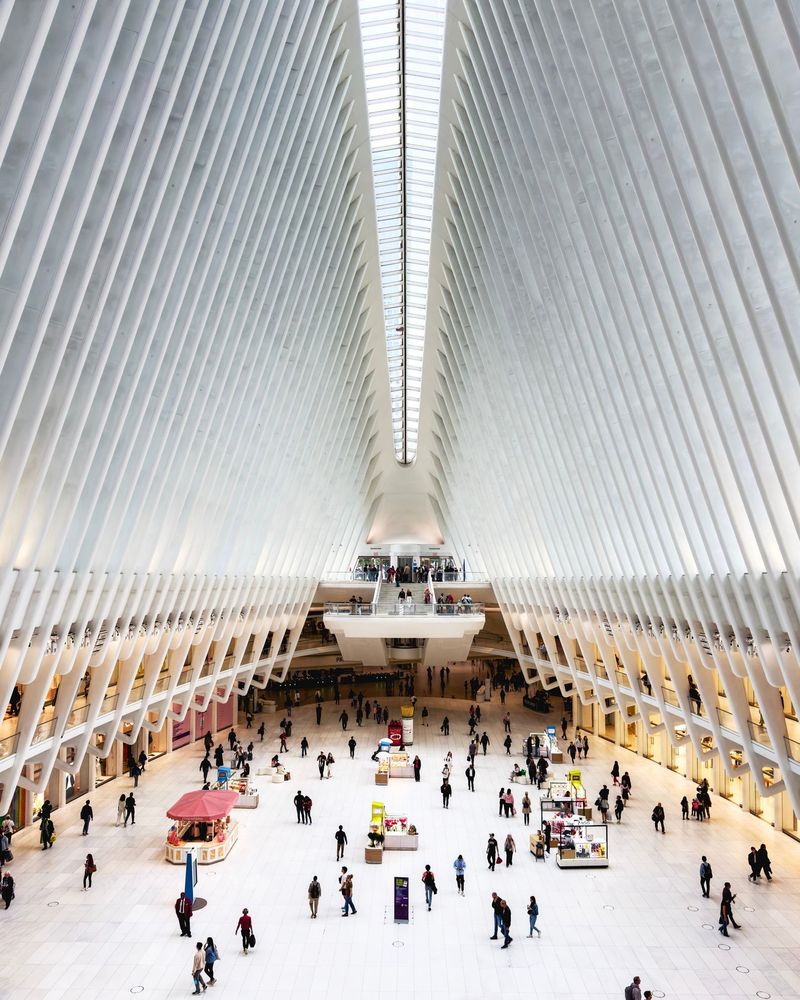People walk through the bright, spacious interior of the Oculus, featuring its futuristic architectural design, in the Financial District, Manhattan, New York.