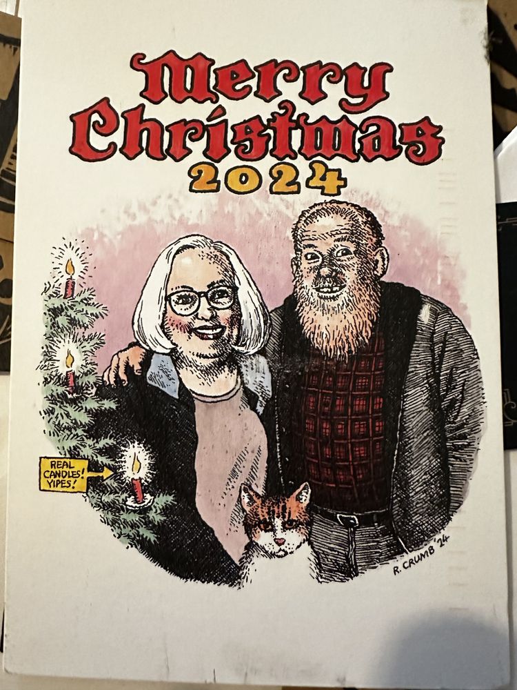 R Crumb artwork portraying a redhaired, bearded man, a white haired woman, and an orange cat with a Christmas Tree (with real candles) along the left side. Says Merry Christmas 2024 along the top.