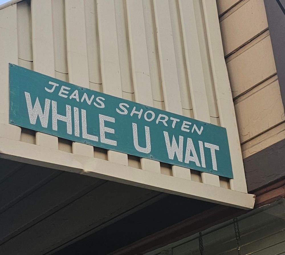 sign: JEANS SHORTEN WHILE U WAIT