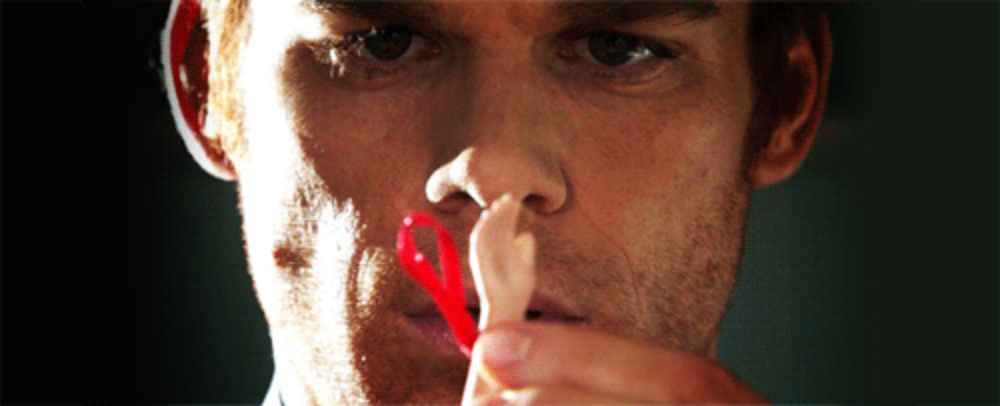 a close up of a man holding a red ribbon in his nose