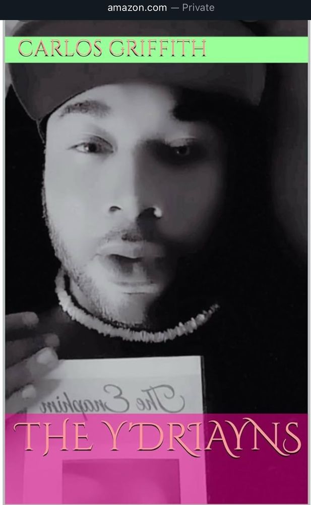 Coven leader Luka lays with his 1st novel The Enaphim on his torso. His handsome countenance is mesmerizing. Half of his face is shadowed in darkness and his eye glows a moonlight color showcasing the other half of himself, his extraterrestrial genetics. He wears a black hooded cardigan,  a necklace and a green ball cap. His eyes stare into your soul. Link in bio to all five novels. 