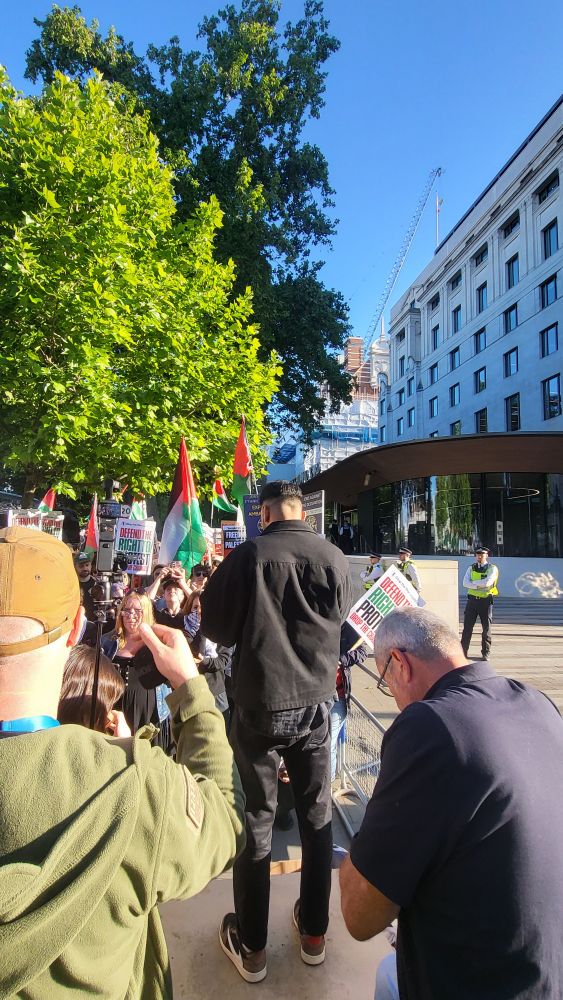 Liberty rep speaking to crowd outside New Scotland Yard 