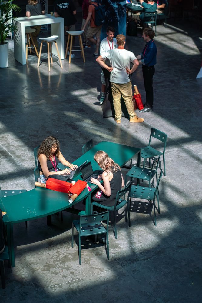 Anne and Chante are sat down with their laptops. 