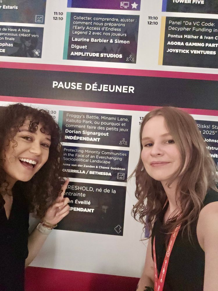 A photo of Anne and Chante pointing to their talk announcement. 