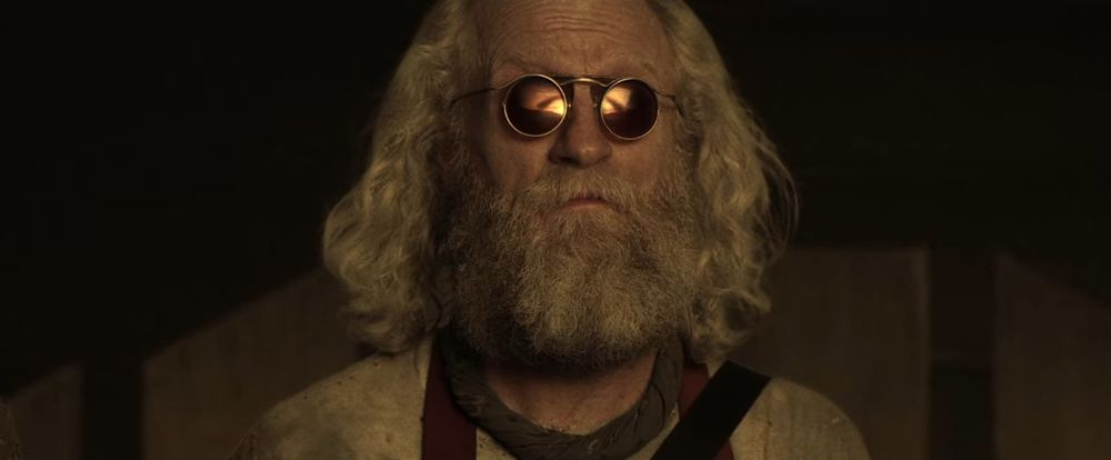 SPOILER ALERT before choosing to continue:

 An image of the bearded old hippie character named "Doc" from the TV show "Z Nation" looks with resigned melancholy at a scene reflected in his round sunglasses, which is a sunset-toned view of an aerial military drone spilling out millions of delivery canisters of a biological agent in an event known as "Black Rainbow." In retrospect, throughout Season 4, the main characters were all set up to fail, and fail they did.