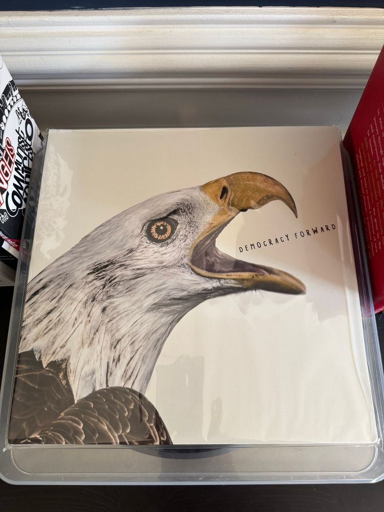 An LP album cover with a bald eagle, mouth open, on white background. The words “DEMOCRACY FORWARD” are in between the upper and lower part of the open beak
