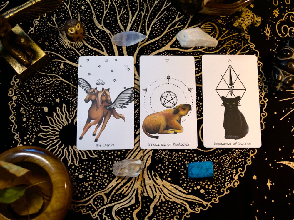 3 Naked Heart Tarot cards on a Tree of Life alter cloth with crystals, leaves and stones and a statue of Isis. 