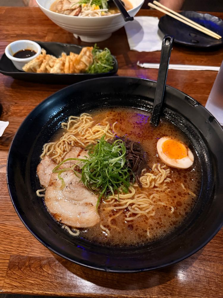 a bowl of fancy ramen with chashu pork and an egg and green onions