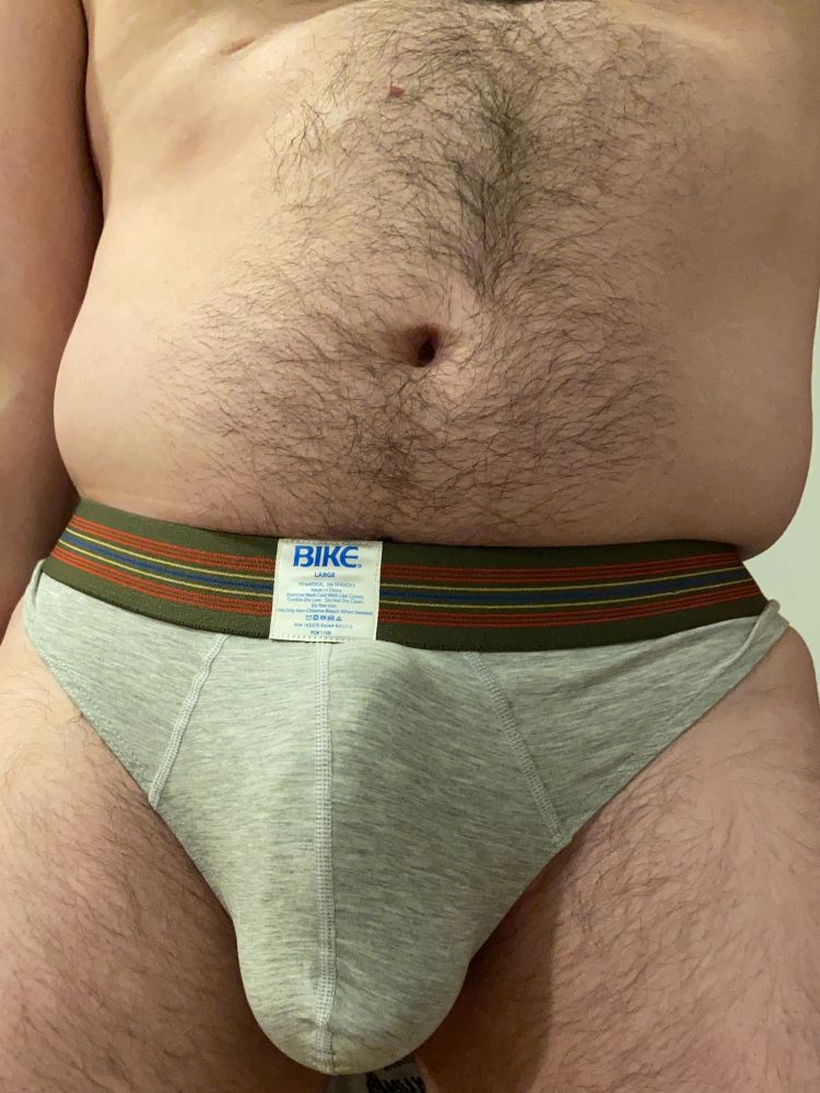 The front of a shirtless human pup in a thong