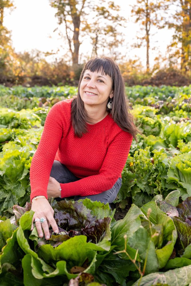 Lane Selman, founder of the Culinary Breeding Network, kneeling in a patch of radicchio.