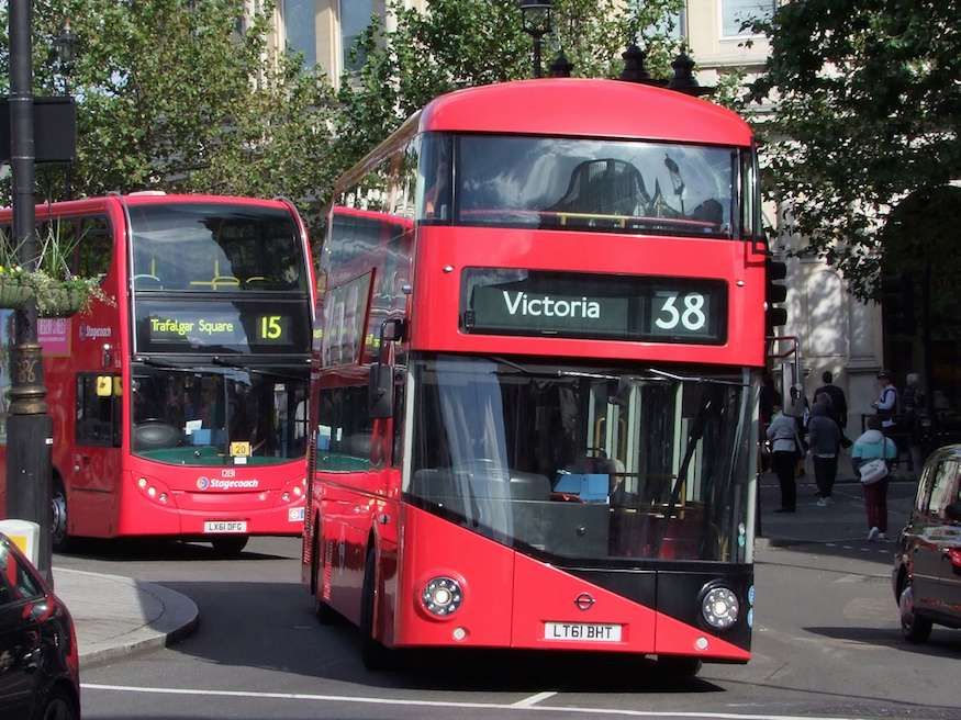 Two red London buses driving towards the camera.