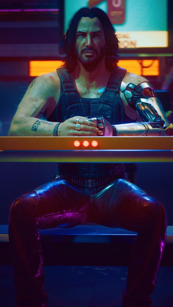 Johnny Silverhand sat down at a table in a restaurant, hands clasped together. Depth of field focused on Johnny. 