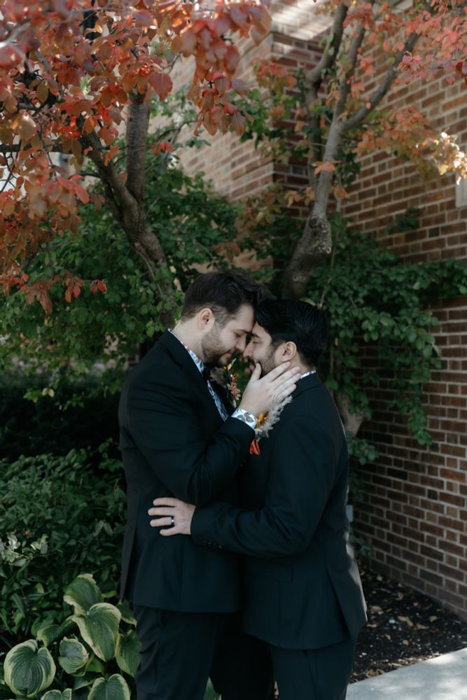 Two men touching foreheads endearingly 