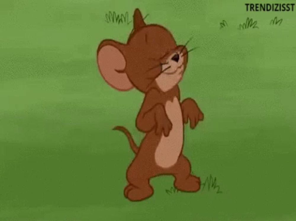 jerry from tom and jerry is standing in the grass with a sad face .