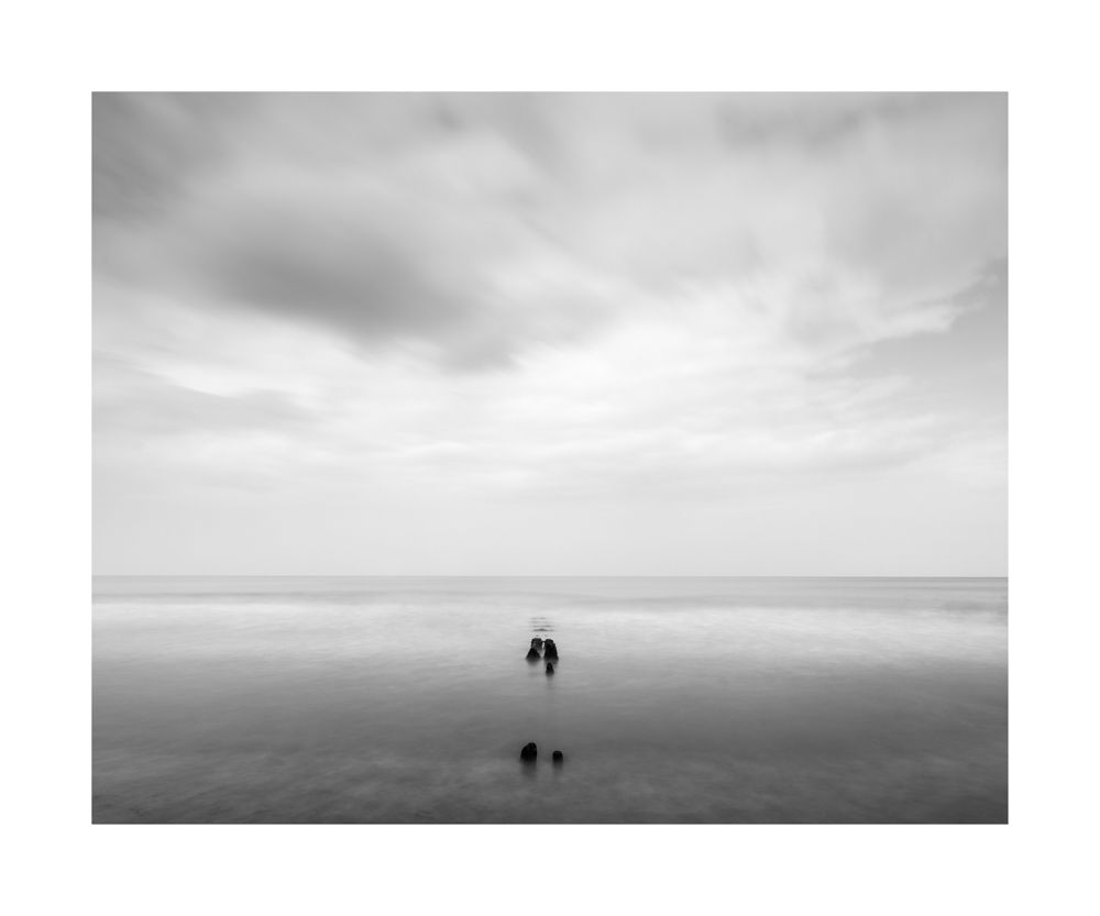 Looking out to the North Sea from Sandsend. A black and white image of some groynes with movement shown in the water 