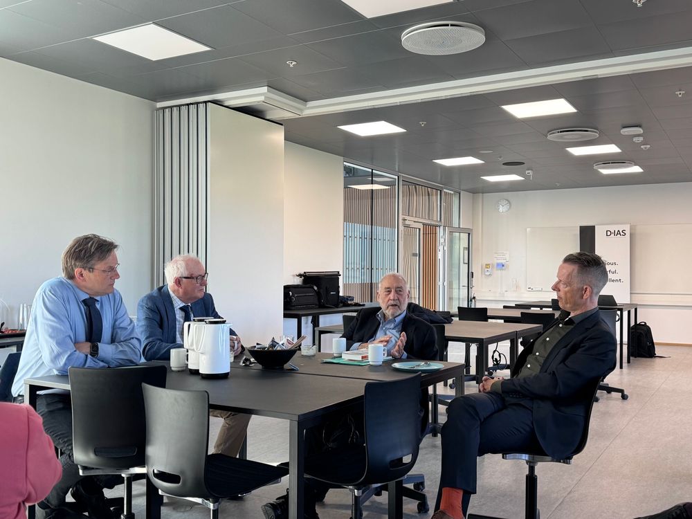 Joseph Stiglitz sitting at a table with three professors from the University of Southern Denmark. They are having breakfast and coffee while talking.