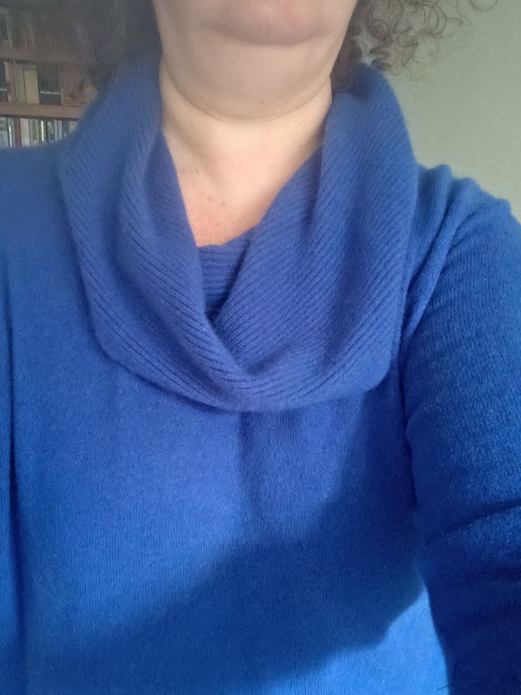 A cobalt blue, cowl neck jumper, being worn by a white woman with brown hair; it's incredibly warm and soft. 