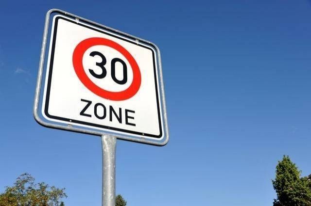 Ein Verkehrsschild Tempo-30-Zone vor blauem Himmel.