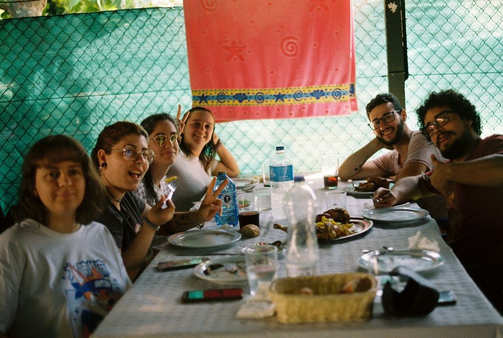 Grupo de amigos comiendo en un chiringuito con efecto de cámara analógica 