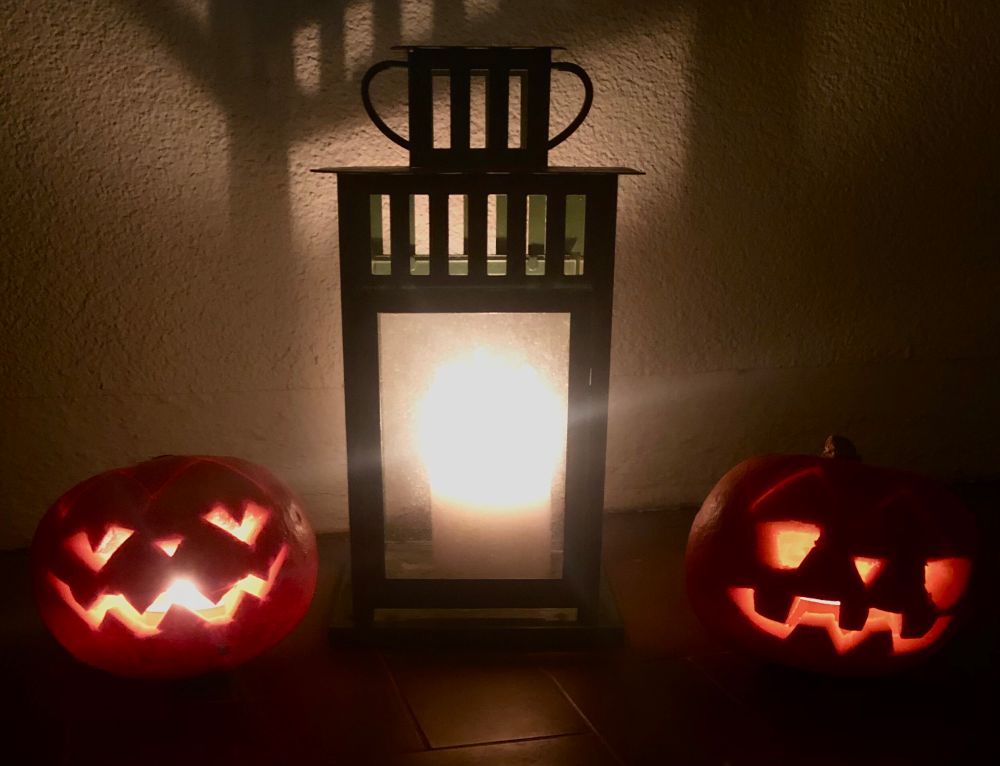 Two MASSIVE pumpkins and a GIANT lantern sit aglow, casting ghostly shadows.