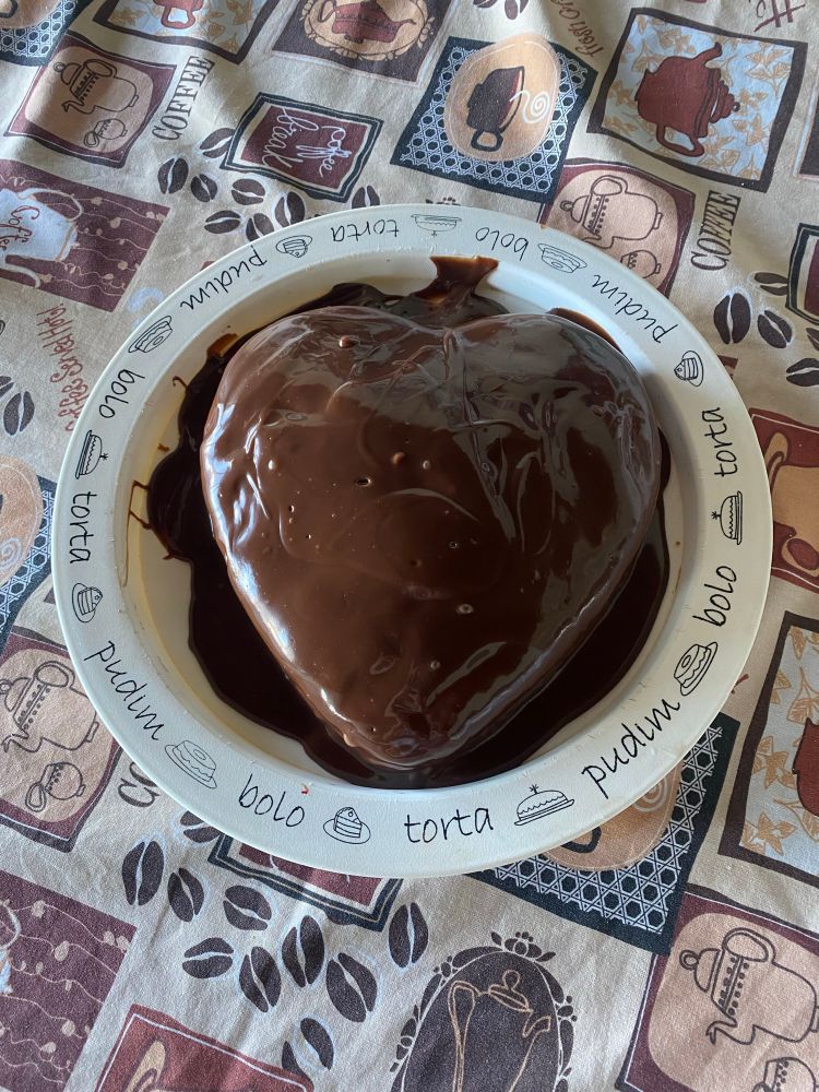 A kinda heart-shaped cake with melted chocolate on top
