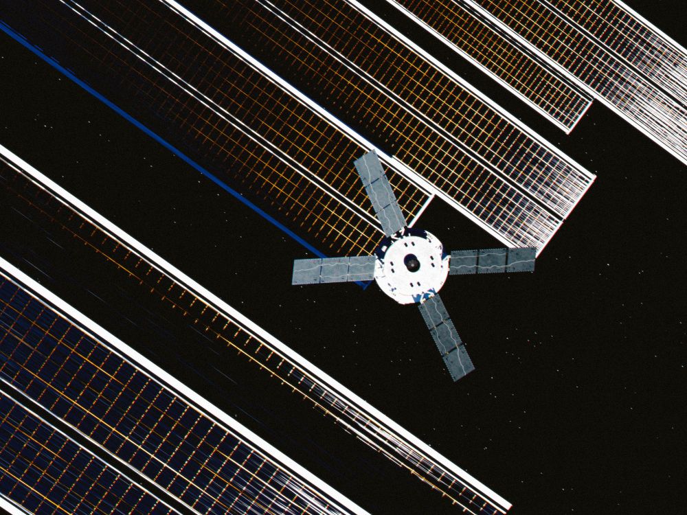 NASA's Orion spaceship against a mysterious background of solar panels. 